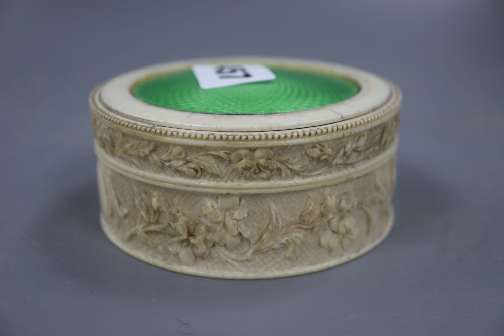 A carved ivory box with an enamel inlaid top, diameter 9.5cm height 4.5cm